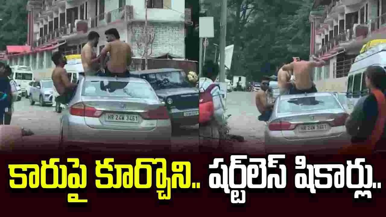 టూరిస్టుల విచిత్ర విన్యాసం.. కారుపై అర్ధనగ్న ప్రయాణం